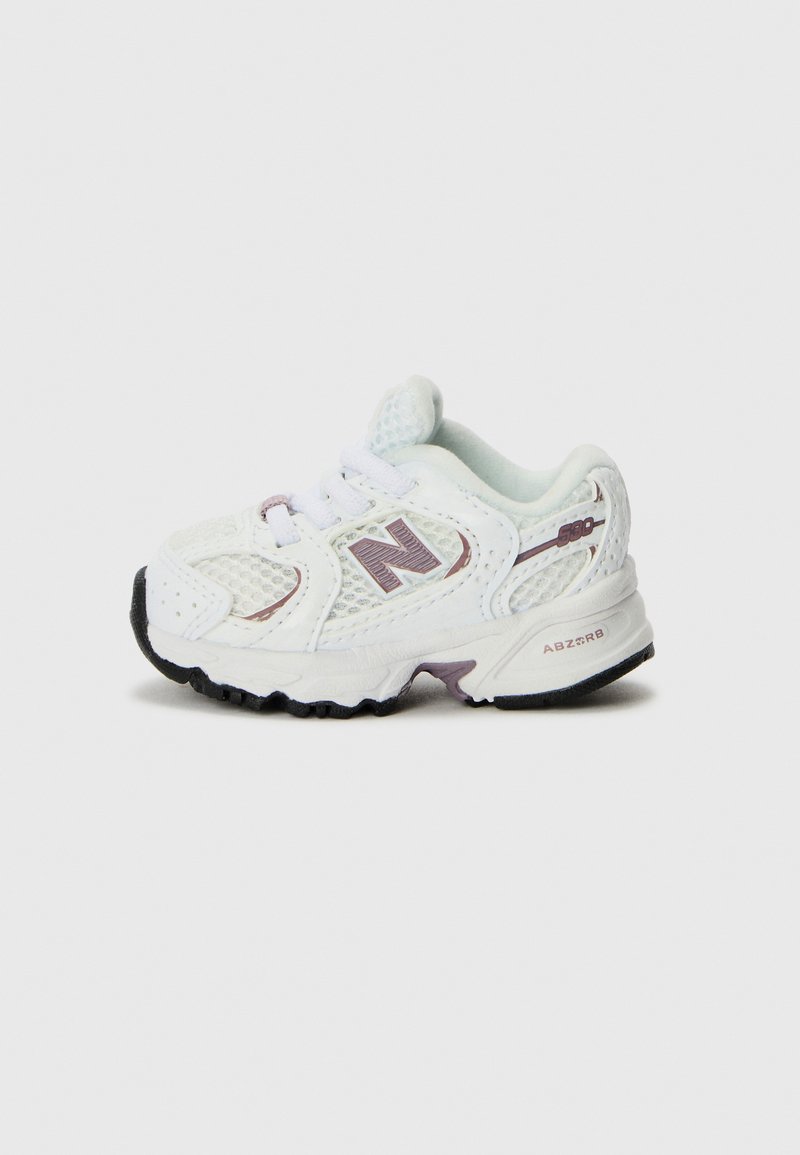 White sneaker with mesh upper, purple accents, and black rubber sole. Features laces and a padded collar for comfort. Lightweight design.