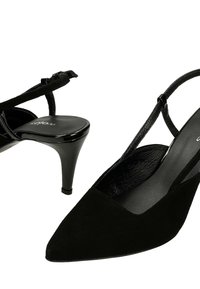 Escarpins slingbacks en daim noir à bouts pointus, avec fines brides autour de la cheville et talons aiguilles hauts et fins, sur fond blanc.