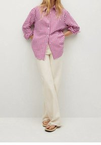 Camisa de botones de manga larga a cuadros rosa y blanca, combinada con pantalones anchos color crema y sandalias de tiras color marrón claro.