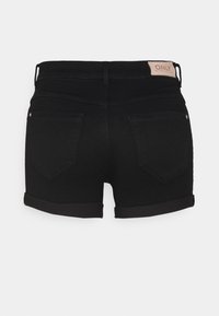 Pantalones cortos de mezclilla negra con dobladillo enrollado, que cuentan con una etiqueta color canela en la parte trasera de la cintura y dos bolsillos traseros. Textura suave y diseño ajustado.