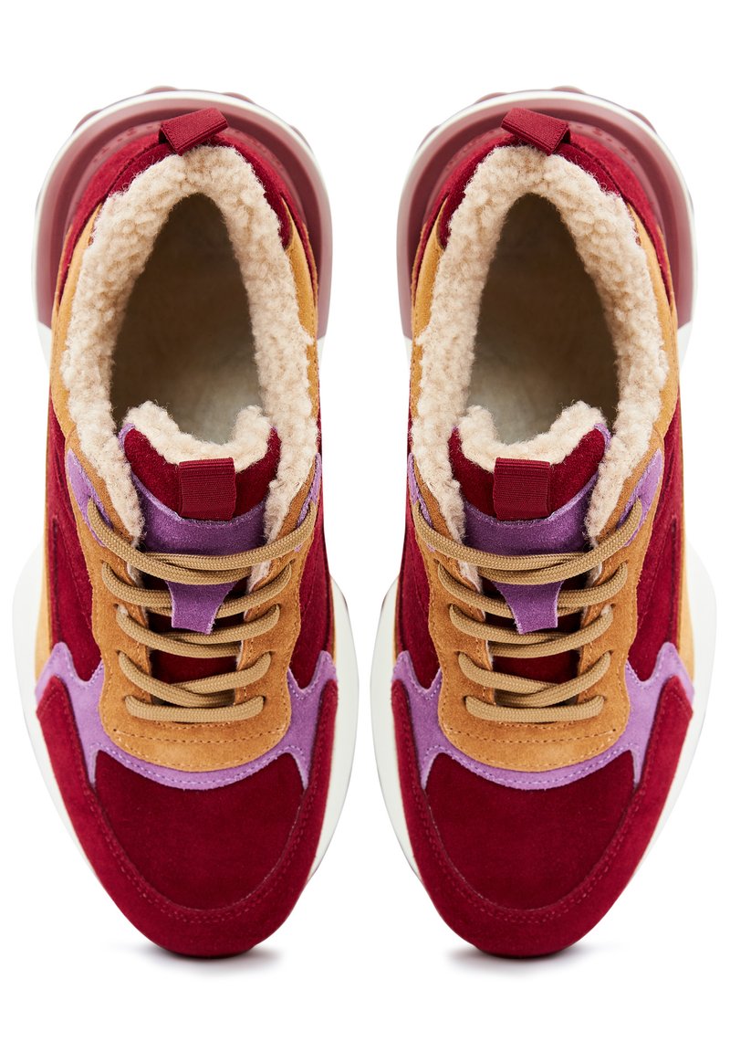 Sneakers in suede rosso e beige con fodera morbida beige, accenti viola e lacci marroni. Presentano una suola spessa bianca e un tassello posteriore.