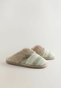 Mules doublés en polaire avec une tige tissée texturée dans des teintes pastel de vert et de crème, dotés d'une bande en fourrure beige et d'une semelle en caoutchouc durable.
