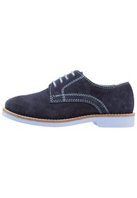 Scarpa alla moda in suede blu navy con cuciture azzurro chiaro, punta arrotondata e suola in gomma con un accento beige. Design classico e superficie liscia.