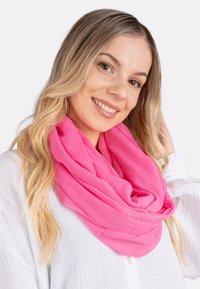 Pink infinity scarf made of lightweight, soft fabric, featuring a smooth texture and layered design, wrapped around the neck.