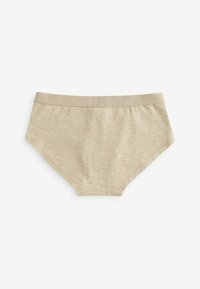 Slip in cotone beige con una texture liscia, dotato di un ampio elastico in vita impresso con il nome del marchio. Design classico a taglio hipster.