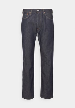 Jean en denim bleu foncé avec jambes droites, bouton et fermeture éclair devant, et design à cinq poches avec surpiqûres contrastées.
