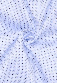 Tessuto blu chiaro con un motivo a pois. Il motivo presenta piccoli pois blu scuro e neri distribuiti uniformemente su una superficie strutturata.