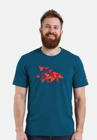 Cyan-kleurige katoenen t-shirt met een geometrisch berenontwerp in rode en oranje tinten met driehoekige vormen, korte mouwen en een ronde halslijn.