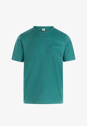 Türkisfarbenes T-Shirt mit kurzen Ärmeln, Rundhalsausschnitt, einer linken Brusttasche und einem kleinen schwarzen Label an der Taschennähte.