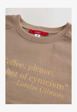 Brown cotton t-shirt featuring a round neckline and printed text in yellow: "Coffee, please, a shot of cynicism." Label reads "next, size 12."