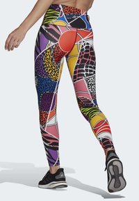 Leggings multicolores avec des motifs géométriques et animaliers, en matériau extensible, taille haute et design ajusté et élégant.