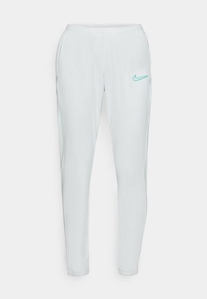 Svijetlo sivi sportski hlače s uskim krojem, elastičnim pojasom i akva plavim Nike logotipom na lijevom bedru. Glatka, rastezljiva tkanina.