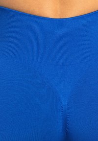 Jasnoniebieskie legginsy z wysokim, prążkowanym pasem w talii i gładką fakturą; mają diamentowy gusset w kroku dla większego komfortu.