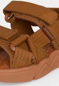 Καφέ προσαρμόσιμο αθλητικό σανδάλι με επενδεδυμένους ιμάντες, υφασμένη σόλα και πλαστικές αγκράφες, με την επωνυμία "bisgaard" στον πλαϊνό ιμάντα.