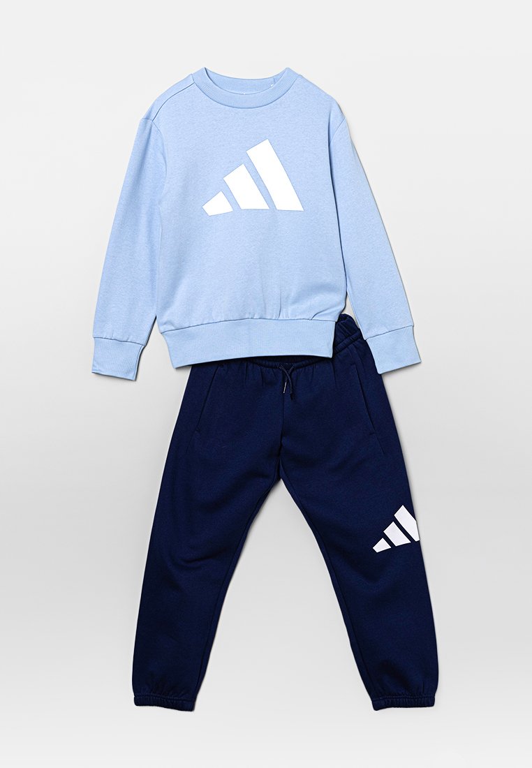 Sudadera azul clara con logo blanco, puños acanalados; pantalones jogger azul marino con detalle de logo blanco, cinturilla elástica y puños en los tobillos.