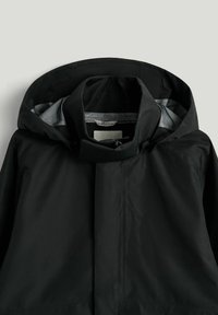 Sort vandtæt jakke med fast hætte, høj krave og lynlås, vist på en neutral baggrund.