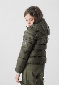 Olijfgroene pufferjack met een capuchon, voorzien van een ritssluiting aan de voorkant en zijzakken. Inclusief een logo-opdruk op de linkerarm. Geweven, gewatteerd ontwerp.