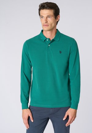 Polo a maniche lunghe verde in cotone, dotato di colletto a costine, di una patta con tre bottoni e di un logo ricamato sul petto.