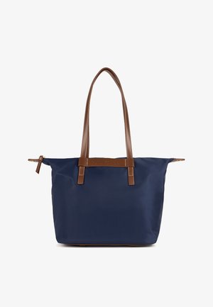 Sac fourre-tout bleu marine en matériau durable avec des anses et des accents en cuir brun. Présente un design minimaliste et un détail de marque à l'avant.