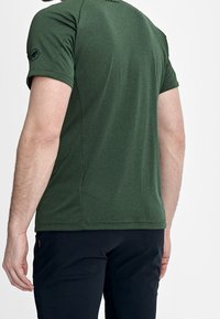 Camisa técnica verde de manga corta fabricada en tejido transpirable, con un diseño sin costuras, un sutil logotipo en la parte posterior y un ajuste regular.