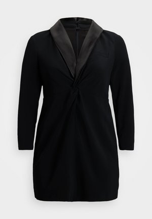 Black dress with long sleeves and satin shawl lapel. Features a twist detail at the waist and a zip closure at the back. Smooth fabric texture.