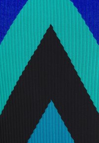 Textile avec motif chevron en bleu, turquoise et noir. Présente une texture côtelée verticale, créant une apparence continue et structurée.