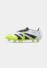 Crampons de soccer noirs et blancs avec des accents vert fluo, présentant un revêtement texturé, un design à bande et des crampons moulés pour une meilleure traction.