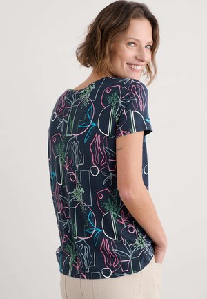 Korte mouwen marineblauwe T-shirt met een geometrisch plantenpatroon in roze, groen en blauw. Zacht materiaal met een ronde halslijn en een relaxte pasvorm.