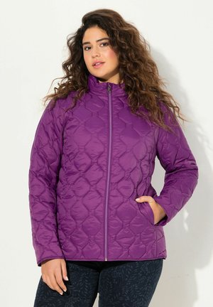 Giacca trapuntata viola con colletto alto e zip frontale, caratterizzata da un motivo a diamanti e tasche frontali. Abbinata a pantaloni scuri con motivo.