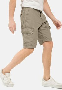 Khaki cargoshorts met meerdere zakken, een relaxte fit en een gestructureerde stof. Draagt met witte sneakers voor een casual uitstraling.
