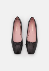 Ballerines en cuir noir avec un bout carré, semelles intérieures rose pâle et un accent de nœud à l'avant. Texture lisse et design minimaliste.