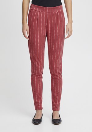 Red striped trousers with narrow white vertical lines, pleated front, fitted shape, and smooth texture, paired with black flats.