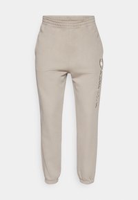 Μπεζ παντελόνι τζόγκερ από μαλακό ύφασμα, με ελαστική μέση και μανσέτες στους αστραγάλους. Διαθέτει πλαϊνή τσέπη με φερμουάρ.