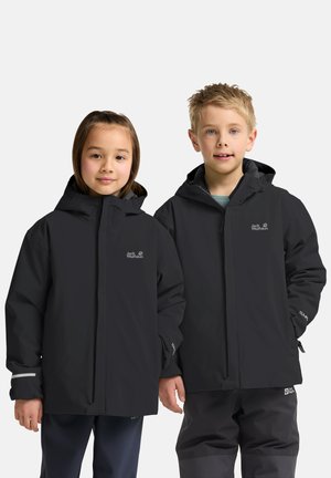 Giubbotti impermeabili neri con cappucci, dotati di chiusura con zip e dettagli riflettenti, indossati su pantaloni scuri, per bambini.