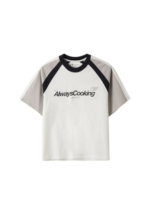 T-shirt blanc à manches courtes avec manches raglan grises et noires et texte "Always Cooking" imprimé sur le devant.