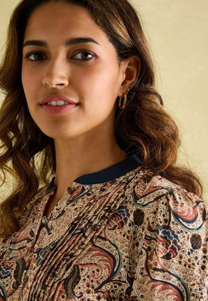 Bluse mit Blumenmuster, V-Ausschnitt und gepresstem Design. Sie hat einen dunklen Kragen und aufwendige, mehrfarbige Paisleymuster.