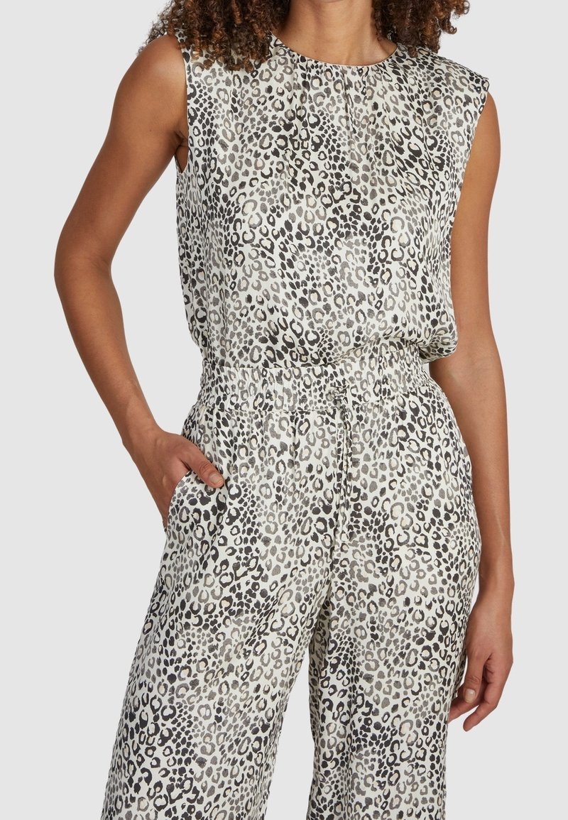 Combinaison imprimé léopard en tons gris clair et noir, avec un design sans manches, une taille élastique et des poches latérales. Texture de tissu lisse.