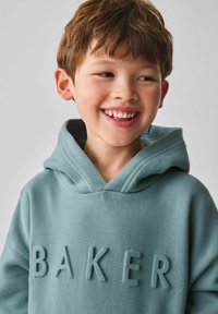 Világoszöld kapucnis pulóver puha anyagból, nagy, kiemelkedő "BAKER" felirattal az elején, tágas kapucnival.