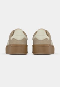 Μπεζ σουέντ αθλητικά παπούτσια με εκρού λεπτομέρειες, που διαθέτουν υφασμένο πάτο με πλατφόρμα. Η φτέρνα έχει λεπτομέρεια λογότυπου και στρογγυλεμένο σχέδιο.