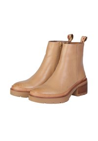 Stivaletti alla caviglia in pelle tan con zipper laterale, suola testurizzata, tacco a blocco e linguette di presa con accenti rossi sulla parte superiore.