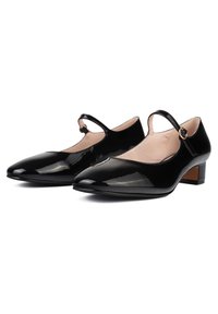 Scarpe Mary Jane in vernice nera con tacco basso a blocco, punta appuntita, cinturino alla caviglia e dettaglio con fibbia circolare in tonalità oro.