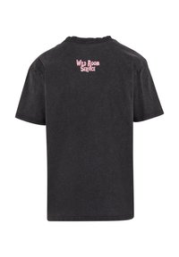 Melnā kokvilnas t-kreklā ar apaļu kaklu, īsām piedurknēm un rozā uzrakstu "WILD ROOM SERVICE" augšējā muguras daļā. Mīksta, nodiluma tekstūra.