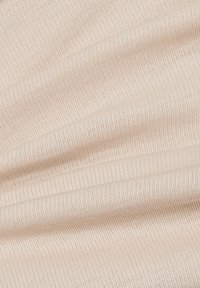 Un tessuto a coste di un beige chiaro con una texture morbida, che presenta righe verticali distanziate uniformemente. Il materiale sembra elastico e liscio.