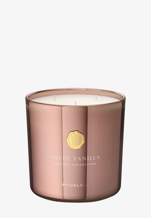 Lysestake i rosegull med tre veker, hvit voks og et gullemblem. Teksten sier «Suede Vanilla Private Collection Rituals.»