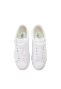 White leather sneakers with round toes, flat white laces, and embossed logo detailing on the tongues. Smooth texture and minimalistic design.