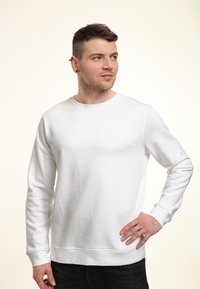 Bílá mikina s kulatým výstřihem vyrobená z bavlněné směsi, s žebrovanými manžetami a lemováním, hladkou texturou a volným střihem.