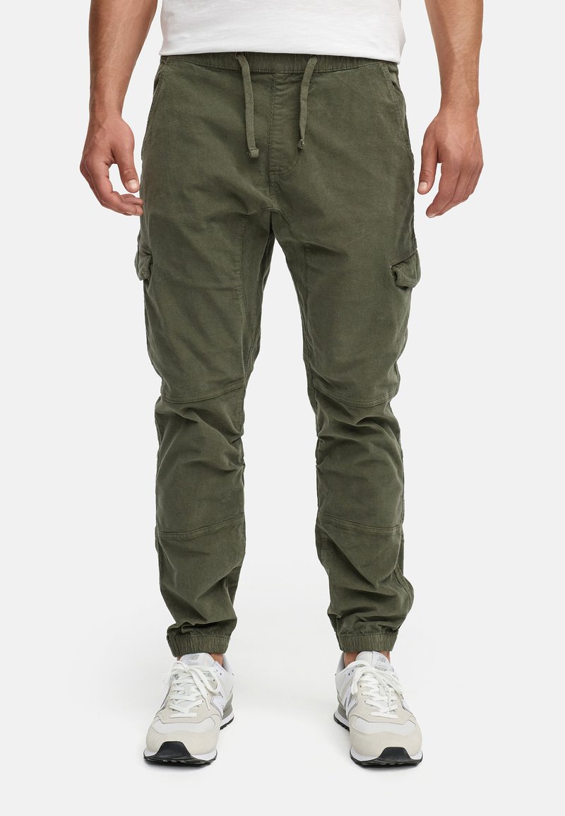 Pantaloni cargo verde oliva con vestibilità affusolata, polsini elastici, vita regolabile e numerose tasche laterali. Materiale in misto cotone con finitura texturizzata.