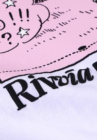 Λευκό ύφασμα με έντονο ροζ καρτουνίστικο σχέδιο με μαύρο περίγραμμα, κείμενο που λέει "Riviera" και διακοσμητικά αστέρια και ερωτηματικά.