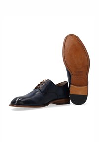 Marine leren schoenen met een gladde afwerking, een gebogen punt, een klassiek vetersysteem, een lichtbruine zool en een geperst merkteken op de onderkant.