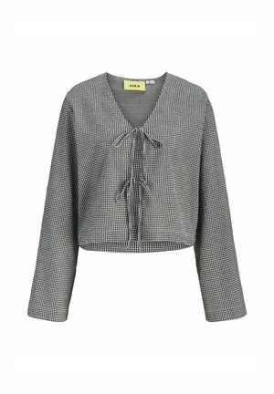 Blouse à manches longues en vichy noir et blanc avec col en V et deux nœuds noués sur le devant, longueur raccourcie, coupe décontractée.